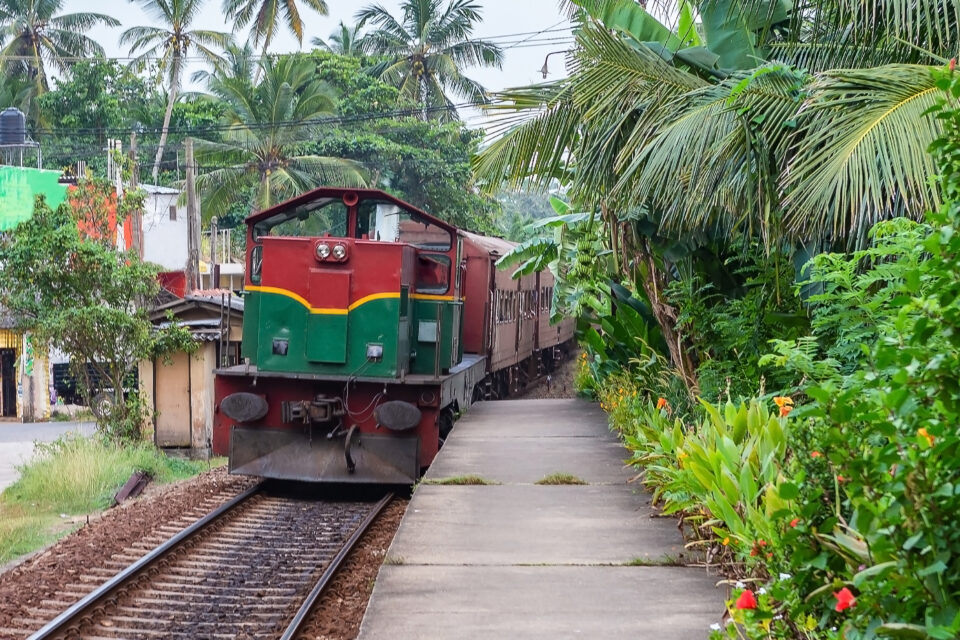 Train stopping at Thiranagama train station. Hikkaduwa, Sri Lanka.